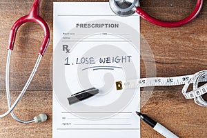 A pen, a tape measure, and a prescription that says Lose weight.