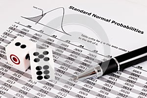 Pen and two dices on standard normal probabilities table.