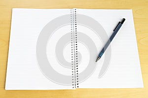 Pen and white blank paper block on table