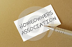 Pen, white paper with text Homeowners Association on the brown background