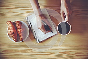 pen writing on notebook with coffee