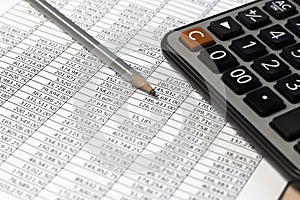 Pencil and calculator on desk table with financial documents