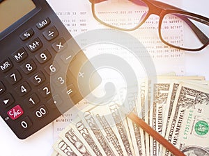 Pencil, calculator, money, eyeglasses and savings account passbook or financial statement on white background