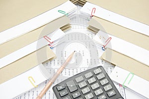 Pencil and calculator between stack paperwork report with envelope