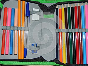 Pencil case with colored pencils, crayons, pen, eraser, sharpener. School concept