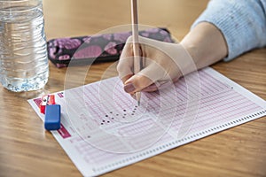 Hand student testing in exercise and taking fill in exam carbon paper computer sheet with pencil at school test room, education