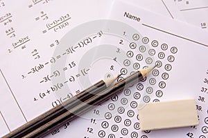 Pencil and eraser on answer sheets or Standardized test form with answers bubbled. multiple choice answer sheet