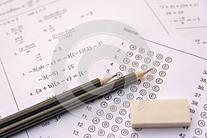 Pencil and eraser on answer sheets or Standardized test form with answers bubbled. multiple choice answer sheet