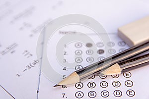 Pencil and eraser on answer sheets or Standardized test form with answers bubbled. multiple choice answer sheet