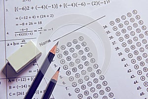 Pencil and eraser on answer sheets or Standardized test form with answers bubbled. multiple choice answer sheet