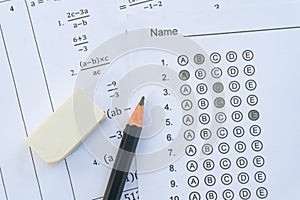 Pencil and eraser on answer sheets or Standardized test form with answers bubbled. multiple choice answer sheet