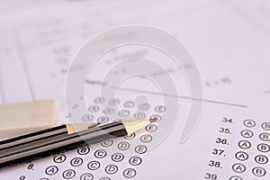 Pencil and eraser on answer sheets or Standardized test form with answers bubbled. multiple choice answer sheet photo