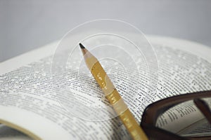 Pencil and glasses on a book