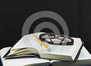 Pencil and glasses on a book