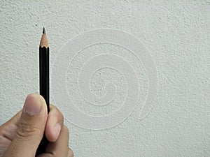 Pencil in a handa with white wall bcakground.