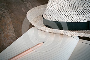 Pencil note book White hat on old wood table1