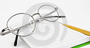 Pencil, notebook and glasses in composition