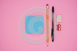 Pencil, pen, scraper, eraser and blank sticky notes. Stationery template. On a pink background, top view