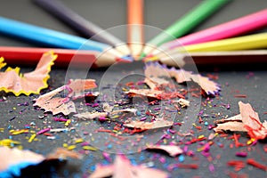 Colored pencils sharp sharpened lie on a table with rubbish