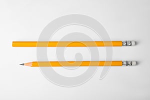 Pencil with point and unsharpened one on background, top view