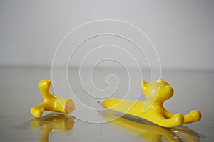 a pencil shaped toy yellow cat, uncovered with the legs recumbent photo