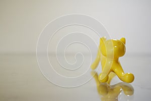 a pencil shaped yellow toy cat in a frontal angle, small, cute and curious photo