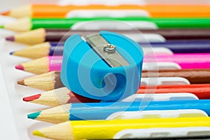 Pencil sharpener on colorful pPencil sharpener on colorful pencils background. School stationeencils background. School stationery