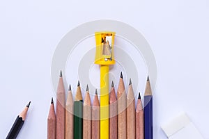 Pencil-sharpener, eraser, and many pencils isolated on white pap