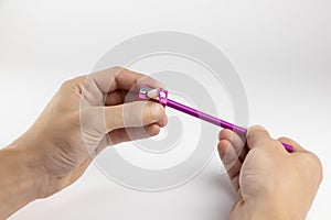 Pencil sharpener. Hands sharpen a pencil on a white background.