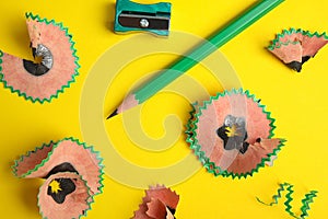 Pencil, sharpener and shavings on yellow background
