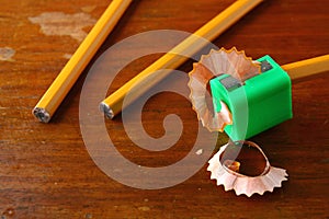 Pencil in a sharpener and two unsharpened pencils