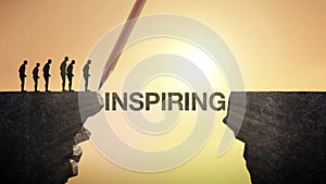 Pencil write 'INSPIRING', connecting the cliff. Businessman crossing the cliff, business concept.