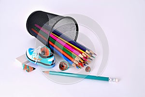 Pencils in a glass, sharpener and eraser on a white background