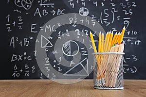 Pencils infront of blackboard with formulas. education concept