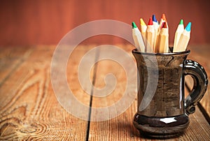 Pencils in a mug on a wooden table