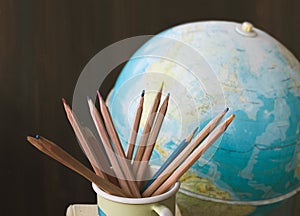 Pencils and old school globe, back to school background