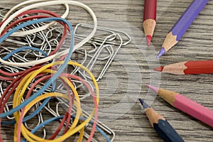 Pencils, rubber bands and clasps on a wood table