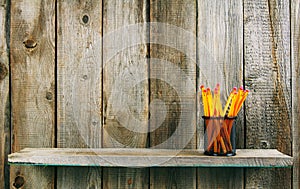 Pencils on a wooden shelf.