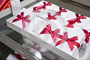 Pendant and earring in the paper box with red bow are display for sales in the fashion jewellry store