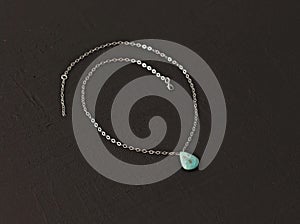 A pendant made of natural stone Turquoise silver chain. Author`s jewelry from natural stones. Designer jewelry. On a black modern