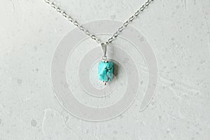 A pendant made of natural stone Turquoise silver chain. Author`s jewelry from natural stones. Designer jewelry. On a light modern