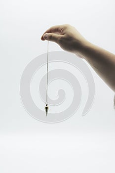 Pendulum dowsing on an isolated white background with a silver point