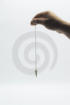 Pendulum dowsing on an isolated white background with a silver point