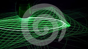 The pendulum draws green laser beams on the phosphor surface. Optical experiment