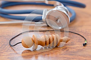 Pendulum and stethoscope on a wooden table