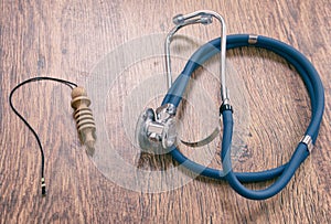 Pendulum and stethoscope on a wooden table