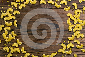 Pene Lisce pasta in the form of a circle on dark wooden background. Top views with clear space photo