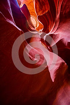 Penetrating light-stained sandstones stacked into flaky waves of fire in a narrow sandy labyrinth in Lower Antelope Canyon in Page