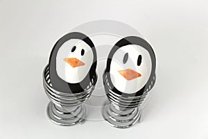 Penguin Easter Eggs on metal egg cup white background