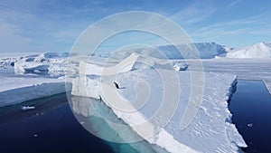 A penguin jumps off an iceberg into the cold ocean.